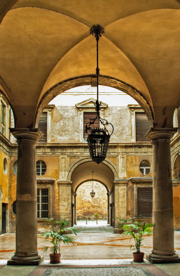 Vaulted portico walkway with a hanging lantern in Bologna