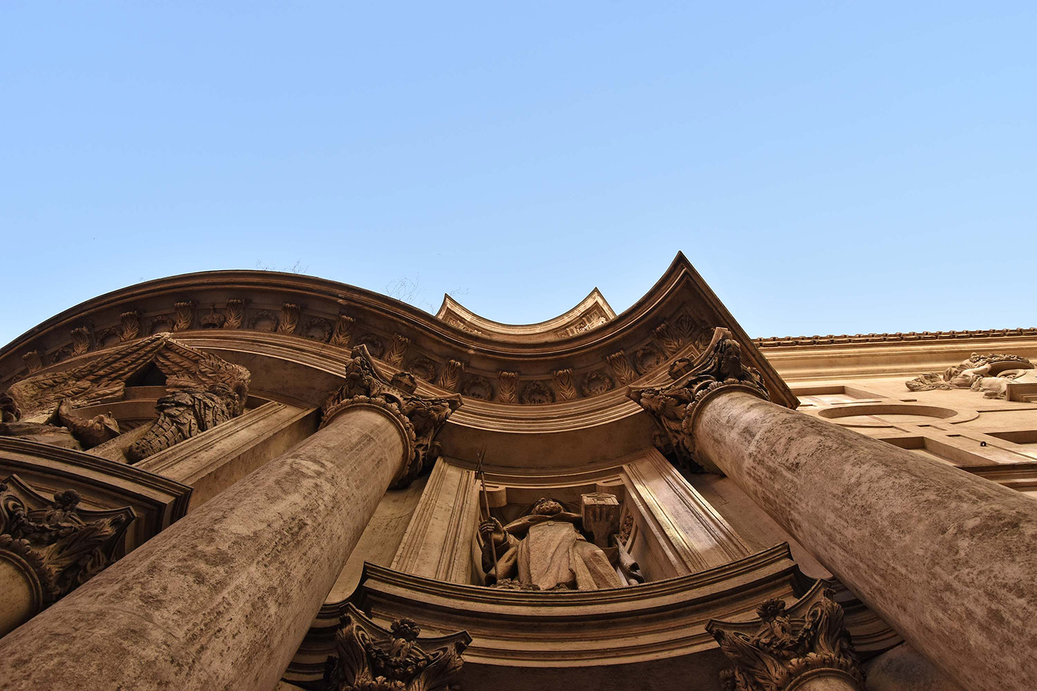 Columns and upper facade of a Baroque church seen from below