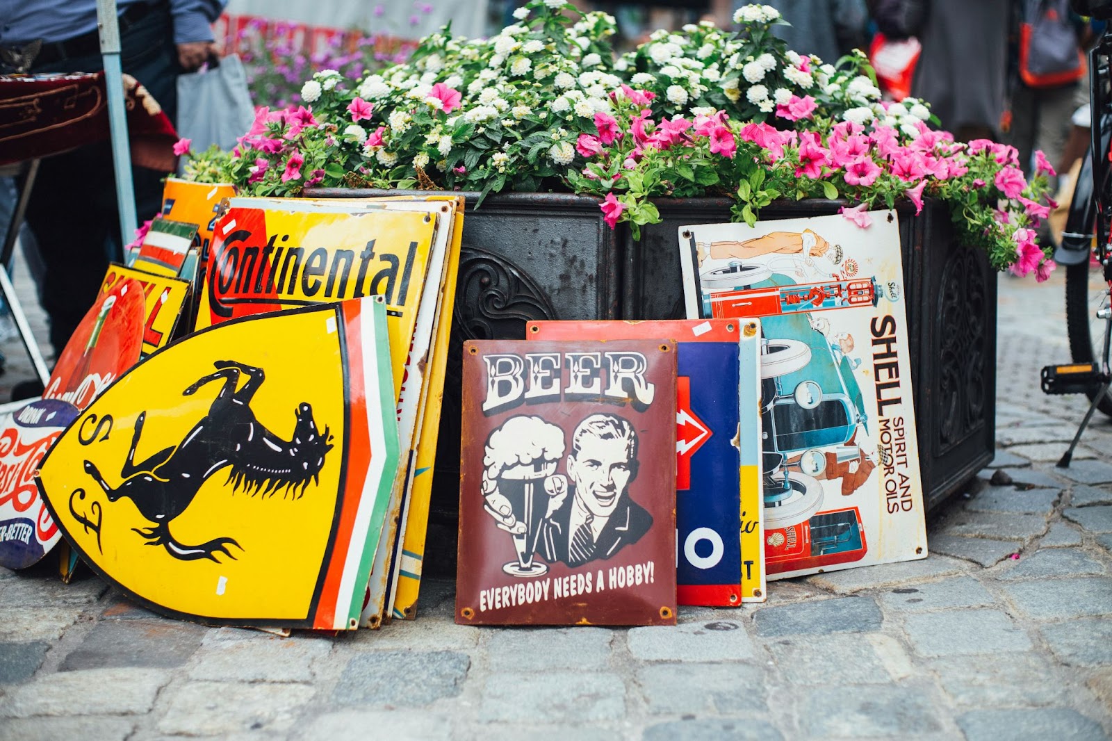 Market stall in Florence displaying vintage painted metal signs