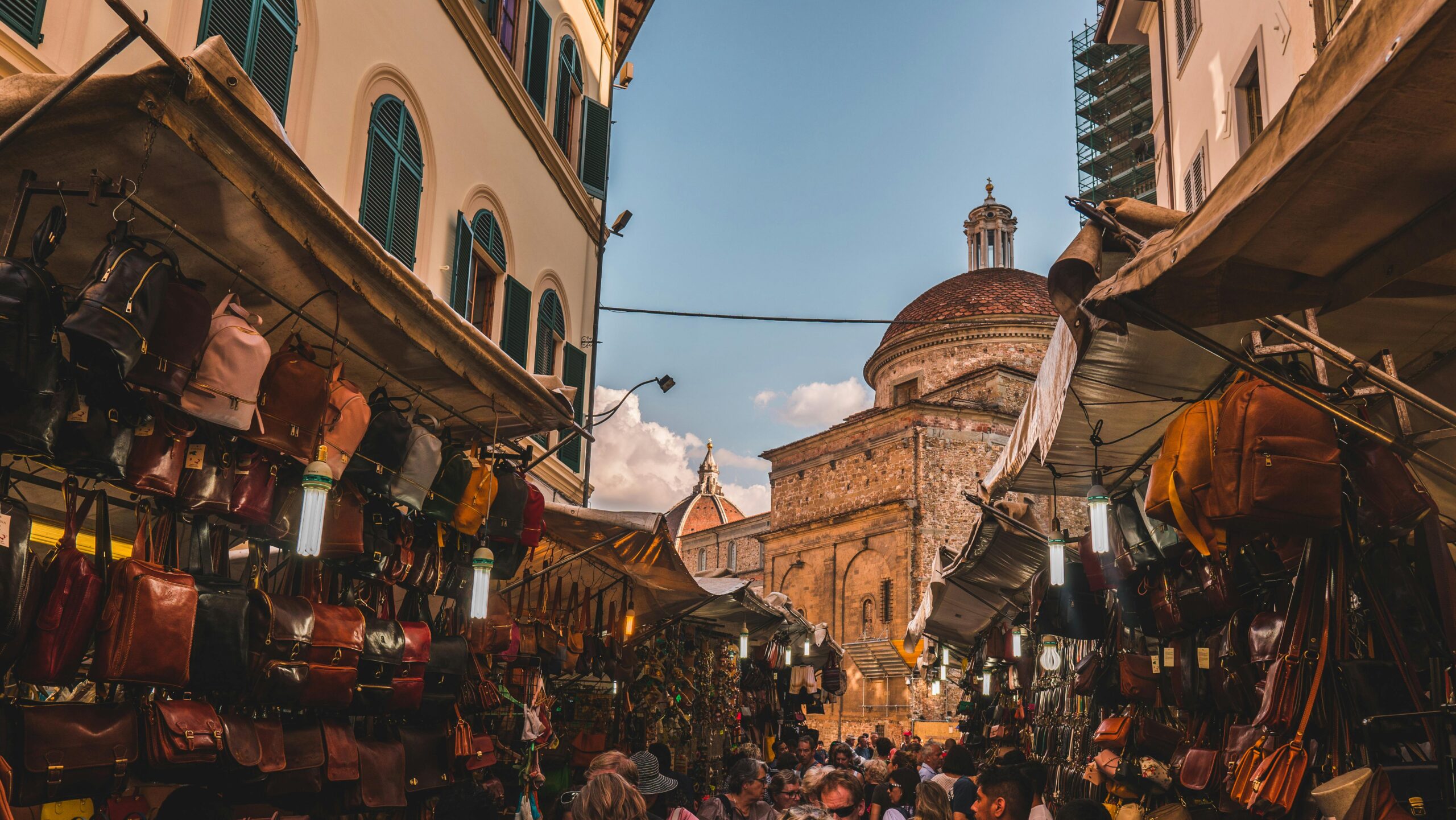Busy Florence street market stalls with a basilica in the background