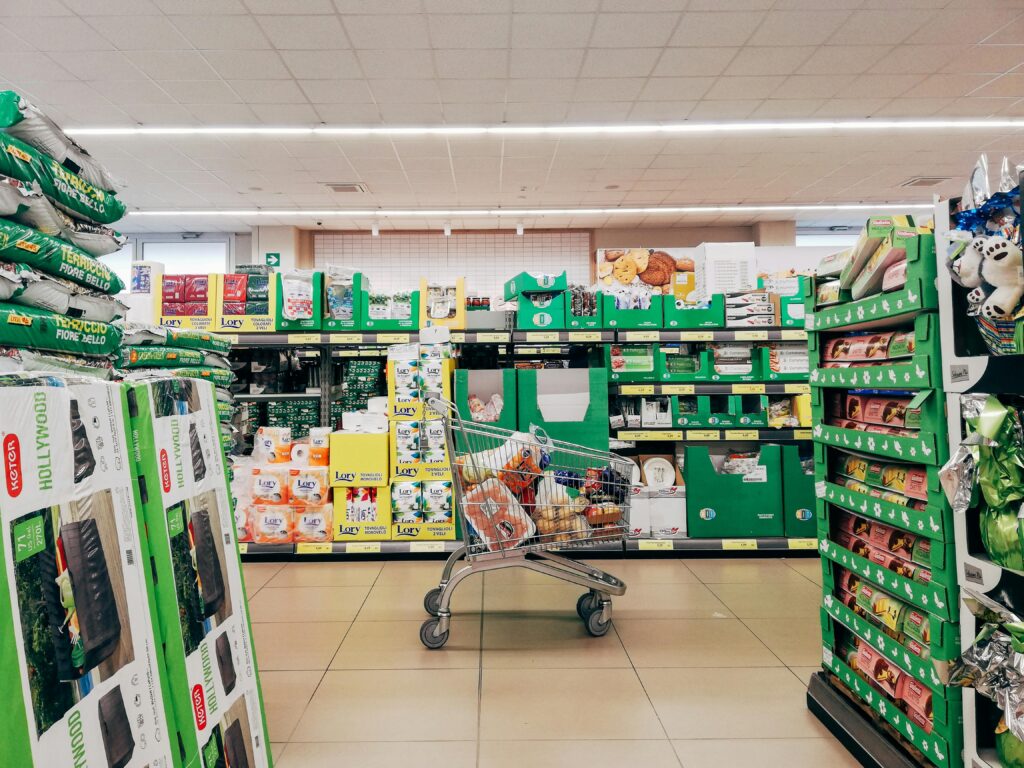 Shopping cart in a vibrant supermarket aisle in Padova, Italy.