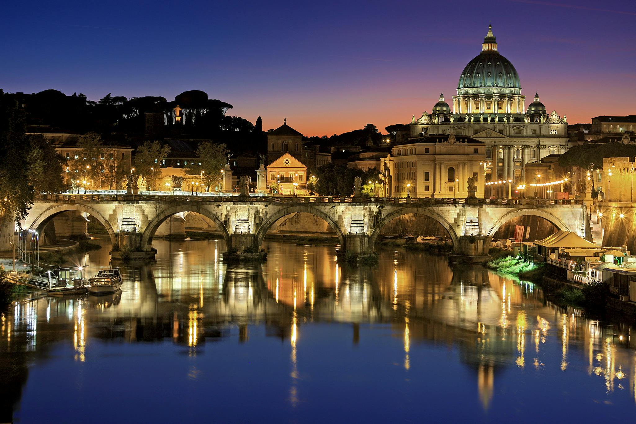 Saint Peter's Basilica and Sant'Angelo Bridge in Rome at sunset