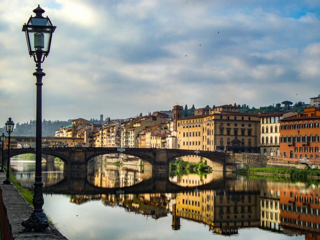 A breathtaking view of Florence's architecture reflecting in the river at dusk, capturing the vibrant essence of Italy.