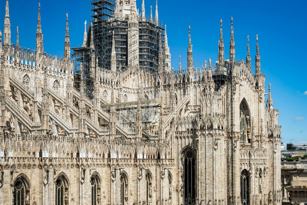 A breathtaking view of the Duomo Cathedral in Milan, showcasing its Gothic architecture under a clear blue sky.