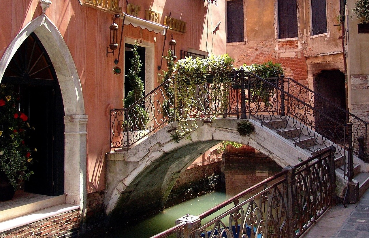 Side canal in Venice crossed by a stepped stone bridge