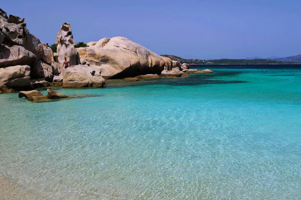 Breathtaking beach with clear turquoise water and unique rock formations under sunny skies.