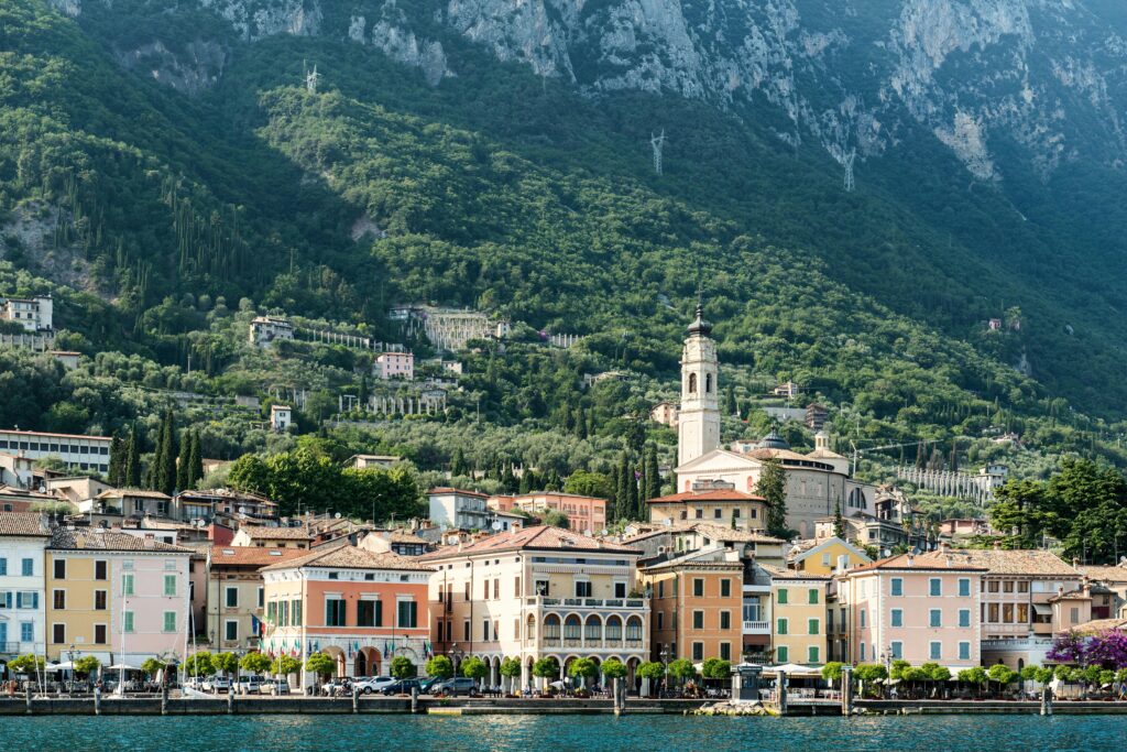 Charming lakefront architecture against lush mountains in Italy, capturing a serene travel destination.