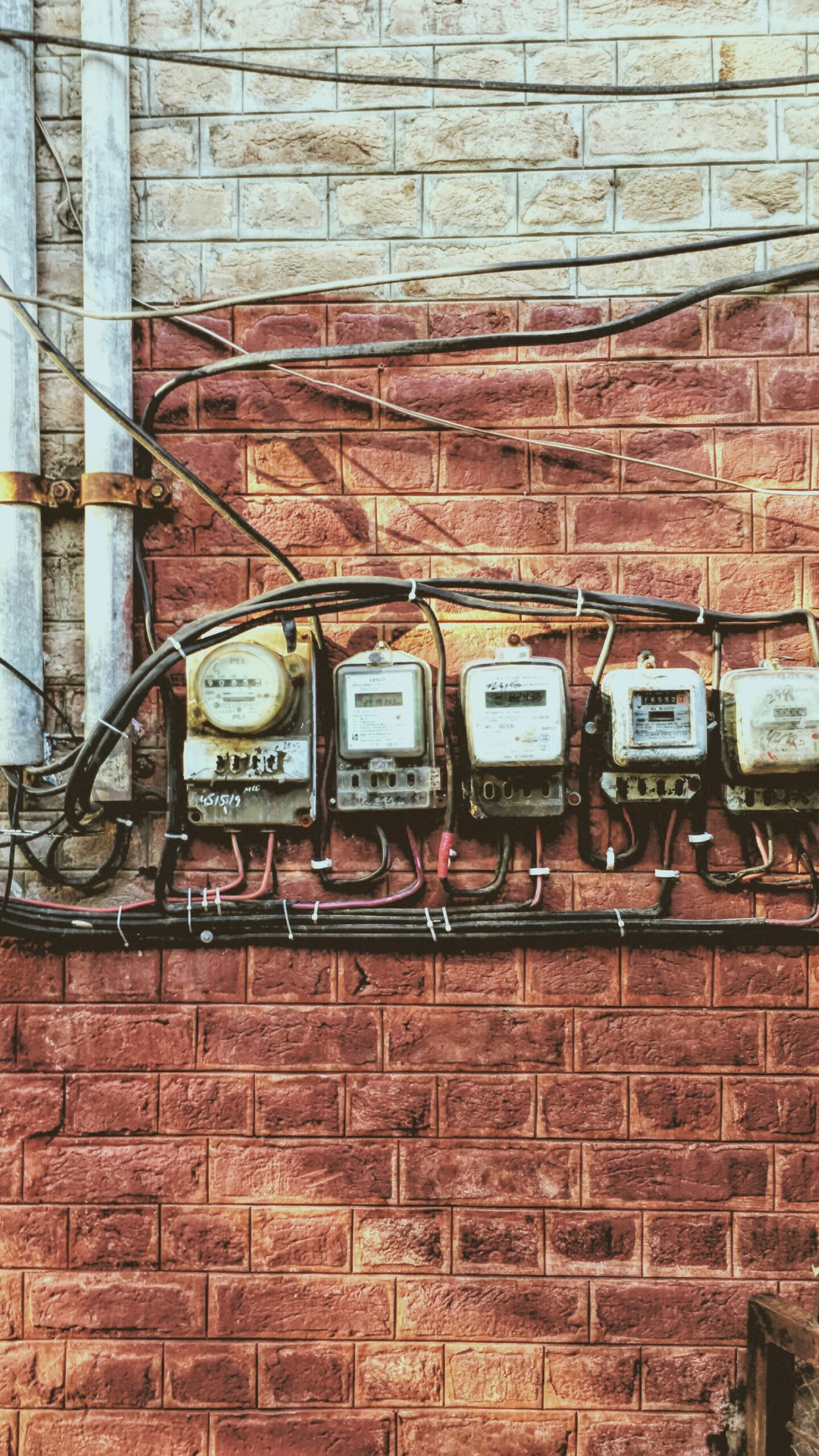 Several electricity meters mounted together on an apartment building wall