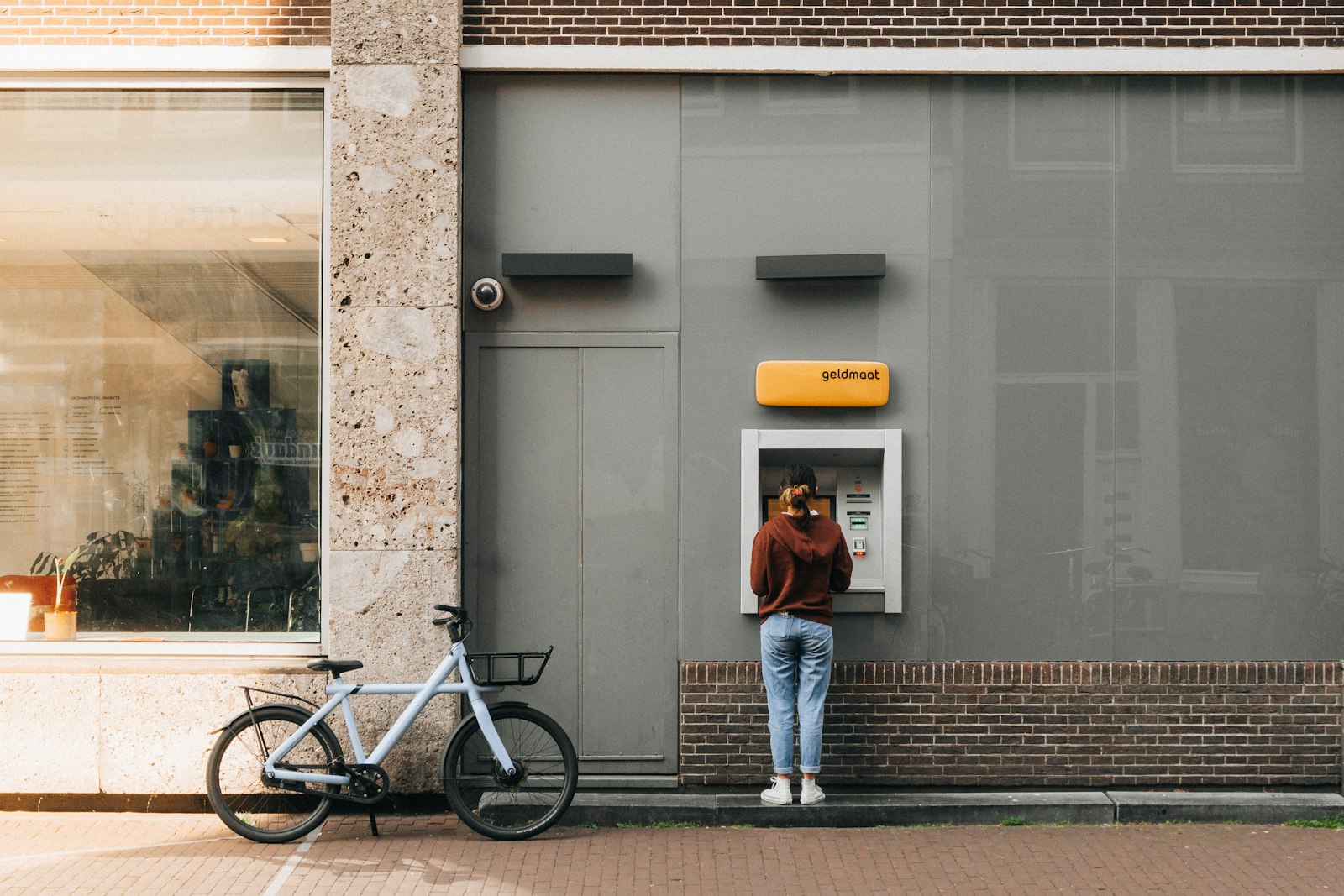 Traveller standing at a bank cash machine on a street in Italy