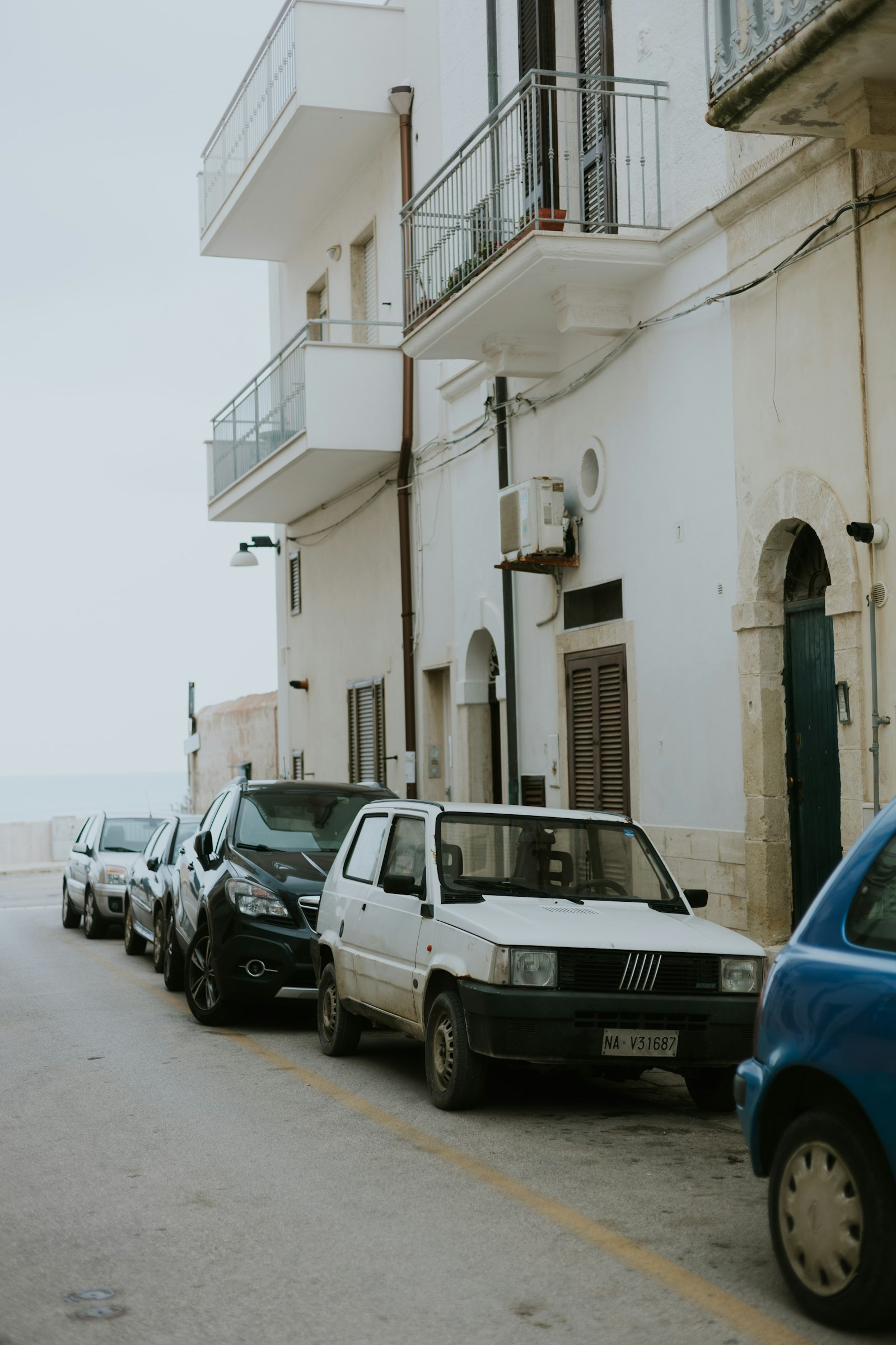 Cars parked in kerbside bays on an Italian street