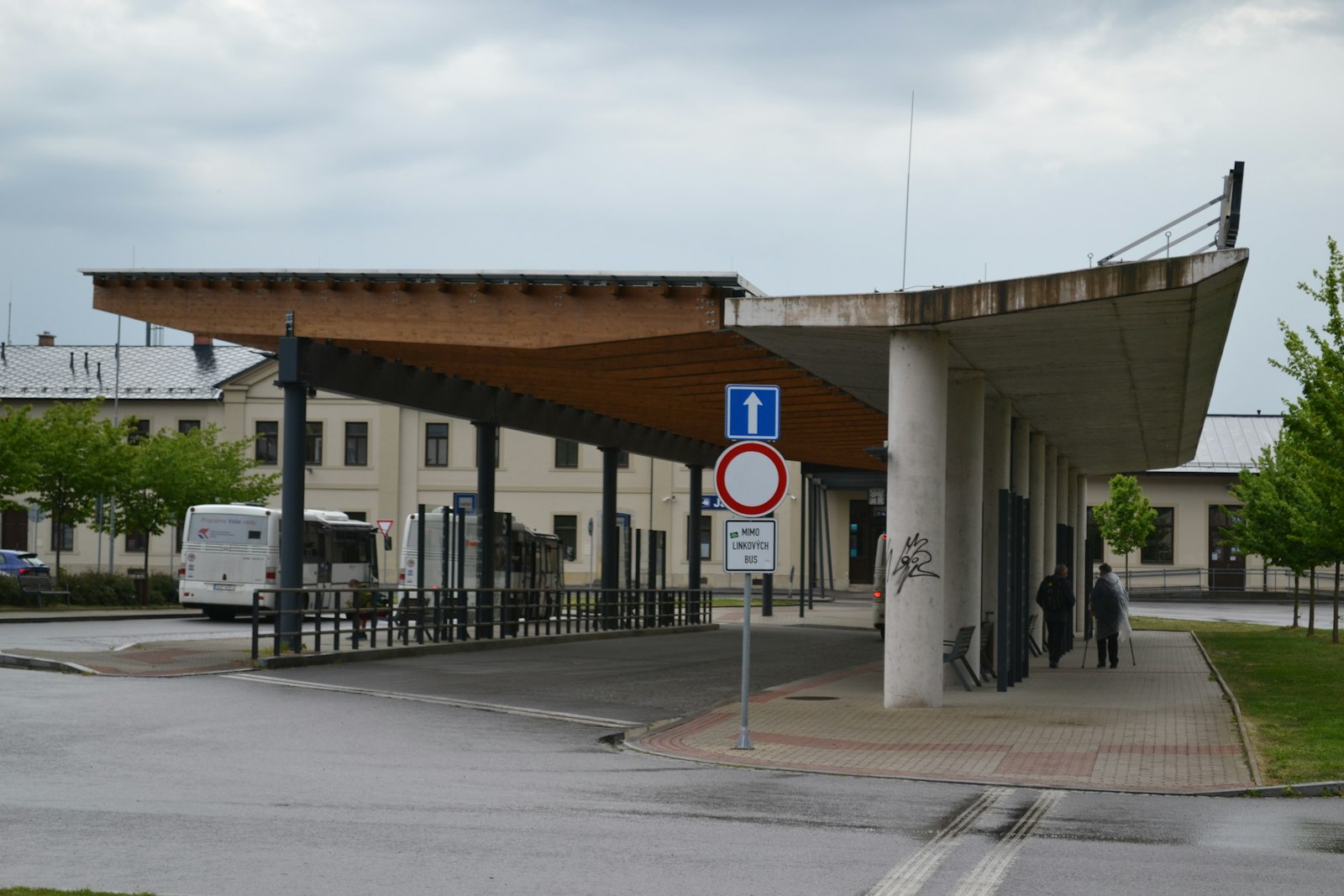 Coach station with passengers walking towards the departure bays