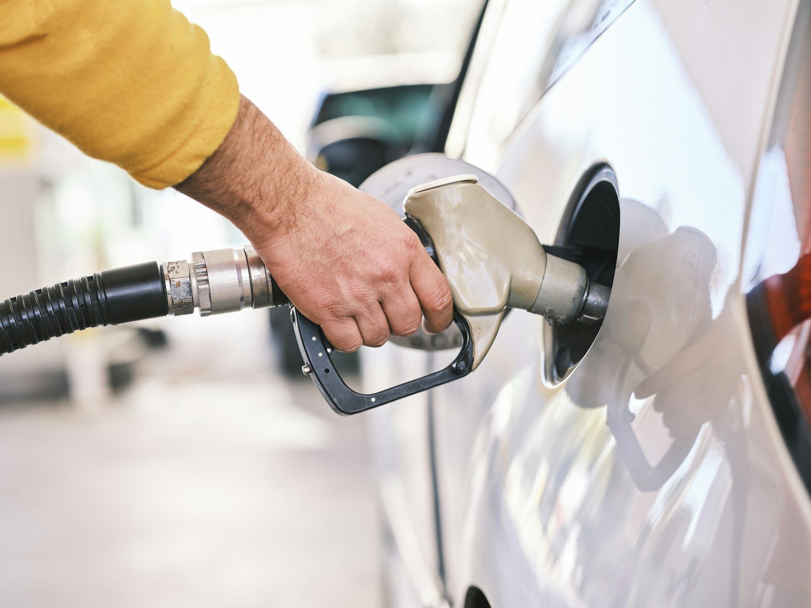 Driver filling a car at a self-service fuel pump