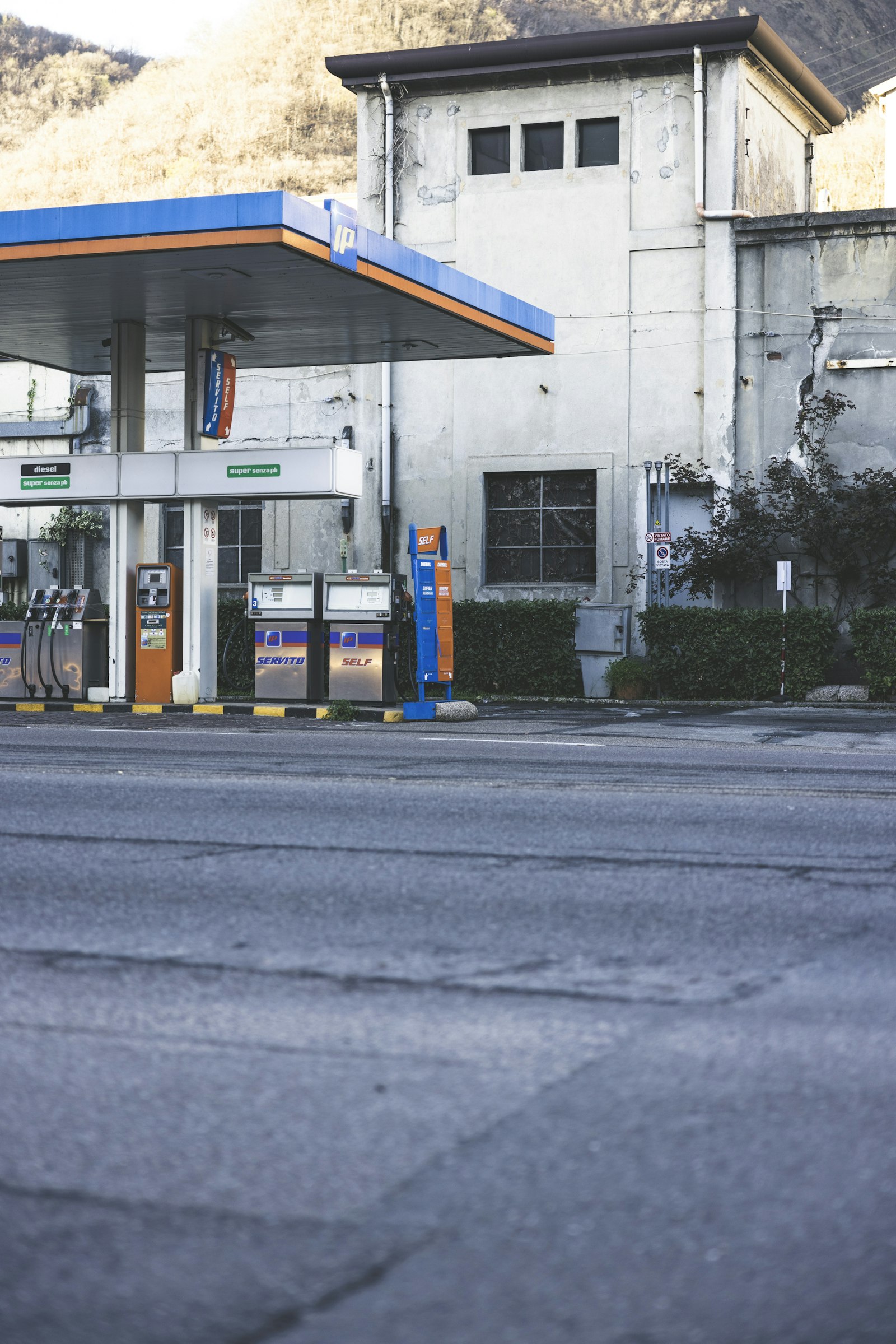 Filling station beside a rural road with hills behind