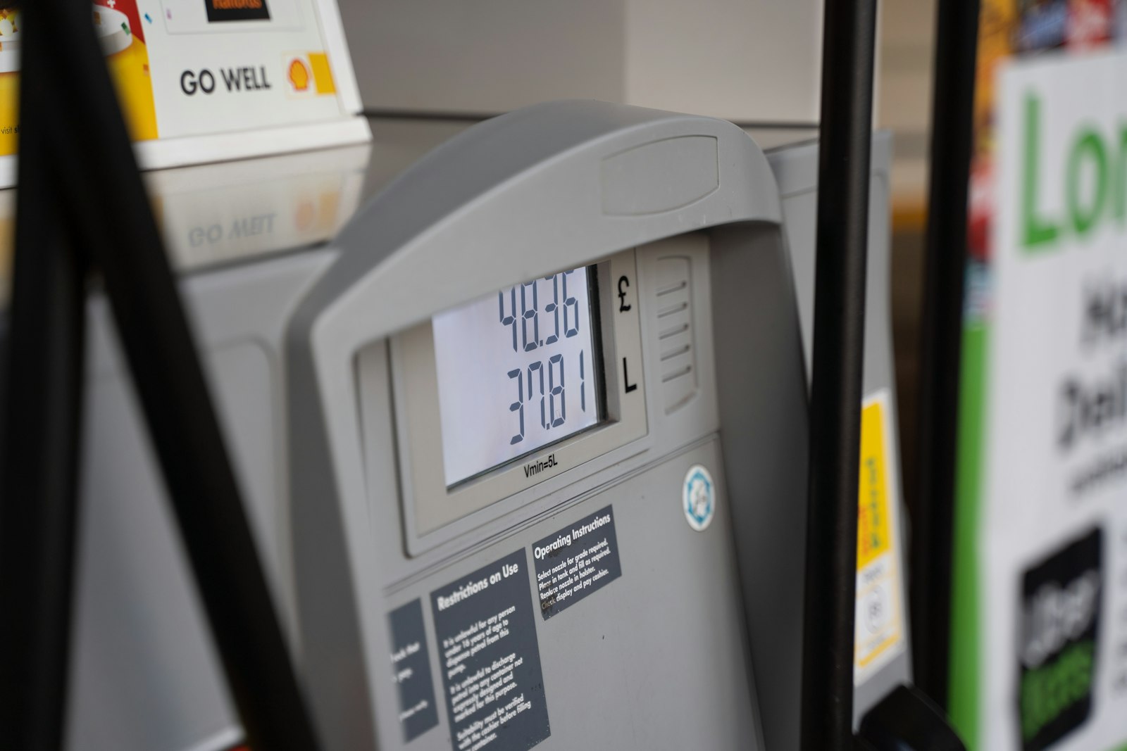Close-up of fuel pump nozzles and their labels at a filling station