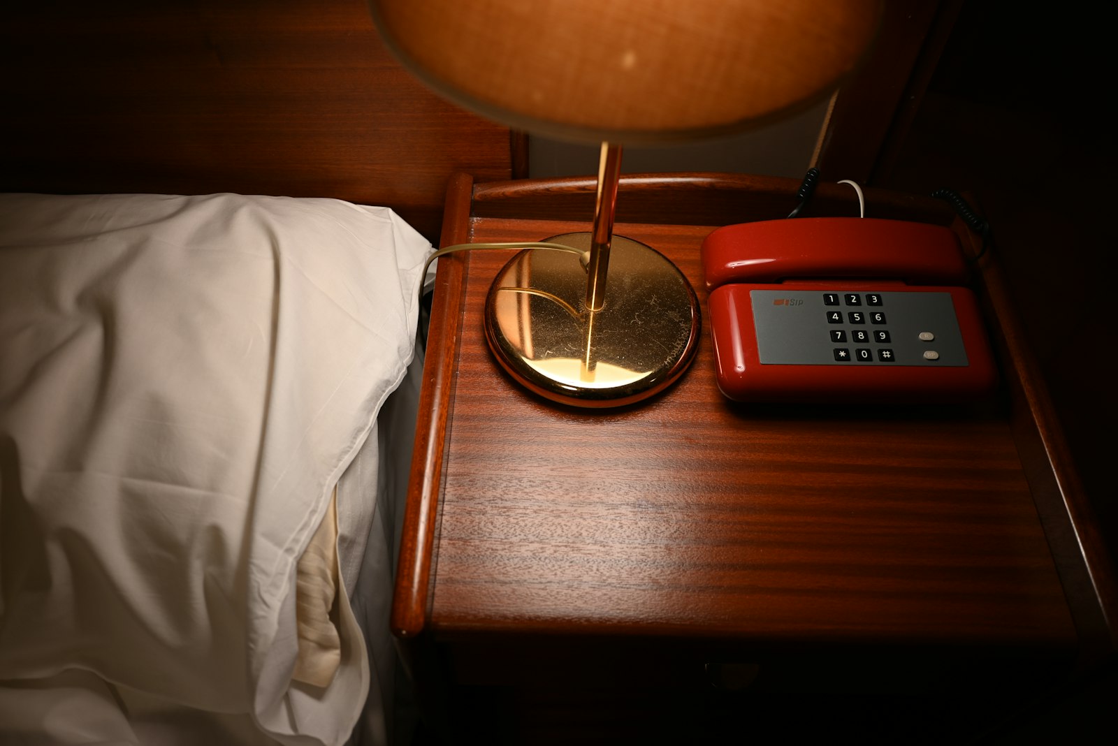 Bedside table with a lamp and telephone in a hotel room