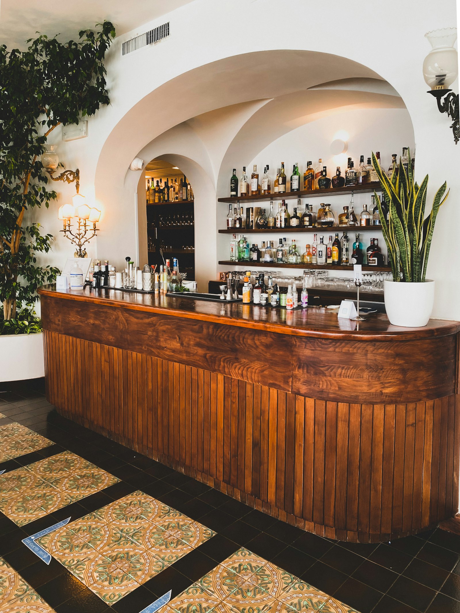Wooden Italian bar counter with bottles and a coffee machine