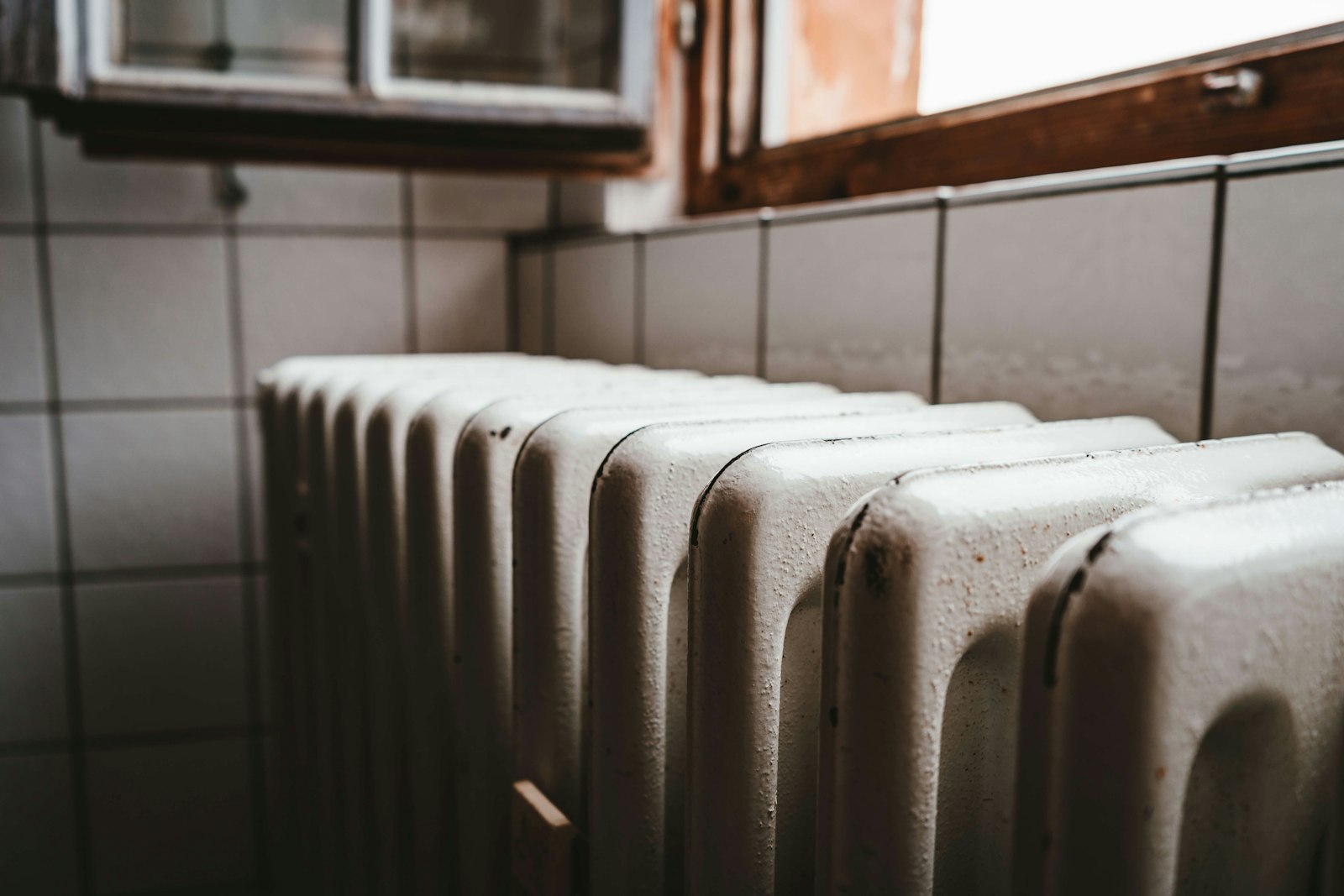 White radiator heater beside a wooden window in a hotel room