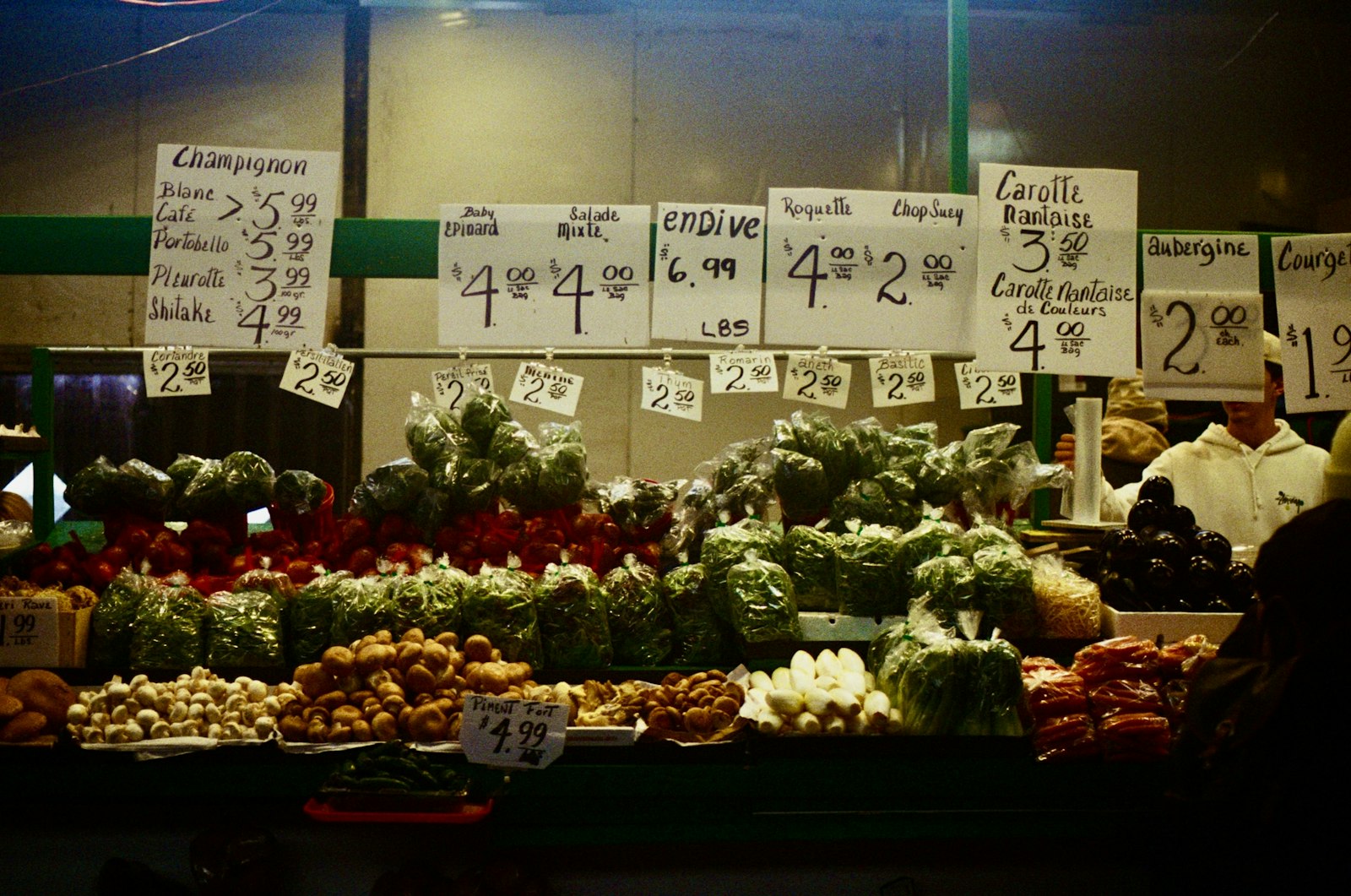 Fresh produce displayed with handwritten price signs at a market stall
