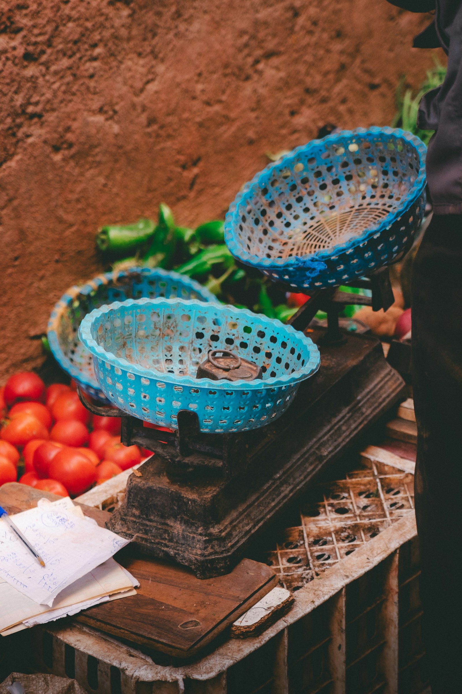 Tomatoes and green peppers being weighed on a market stall scale