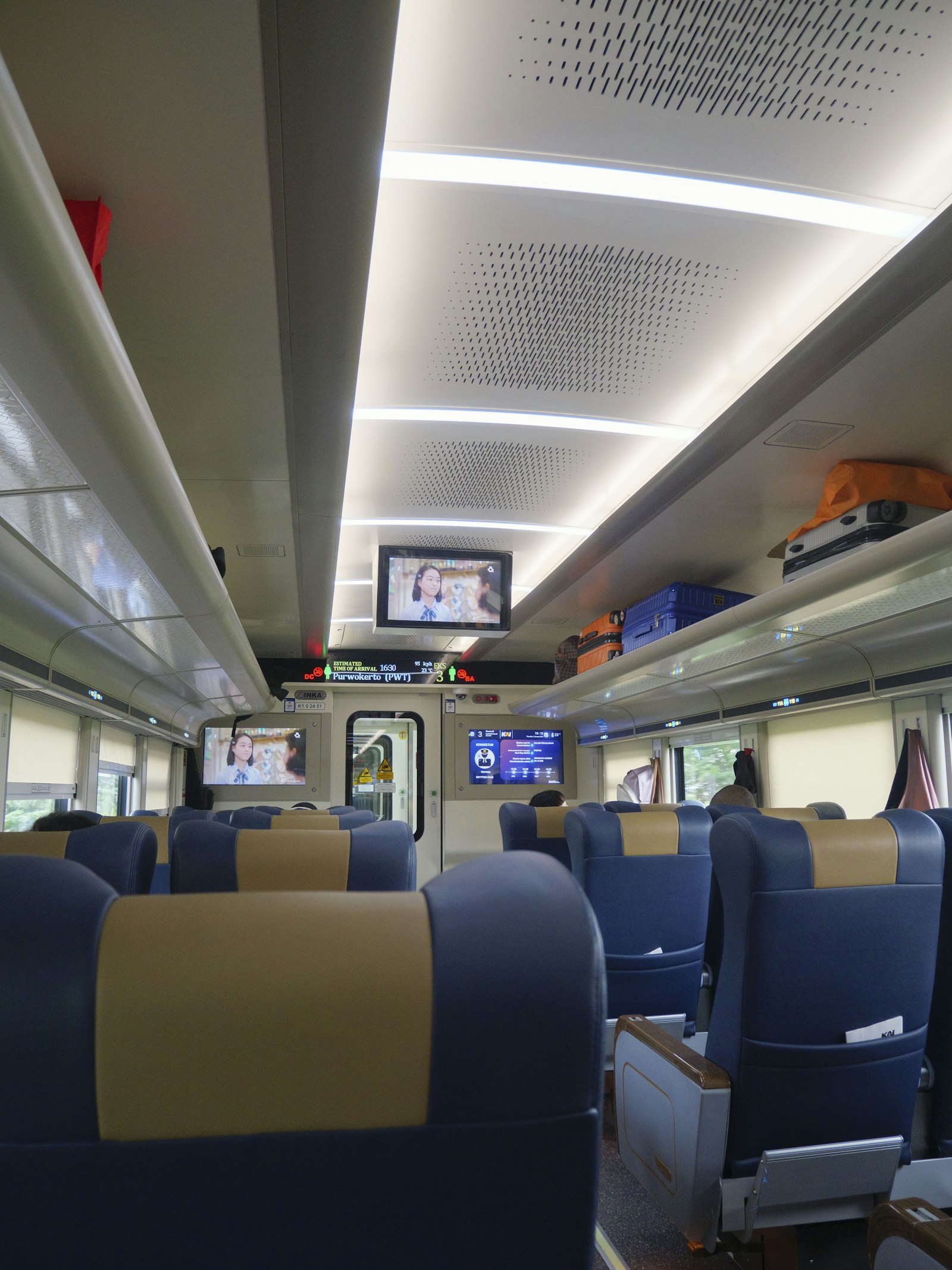 Interior of a modern train carriage seen along the aisle