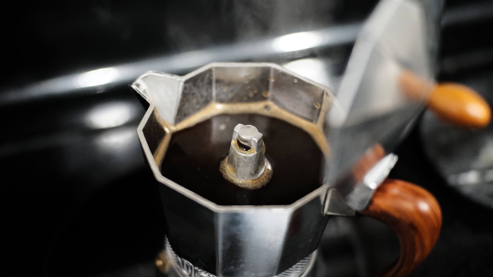 Classic aluminium moka pot coffee maker standing on a kitchen surface