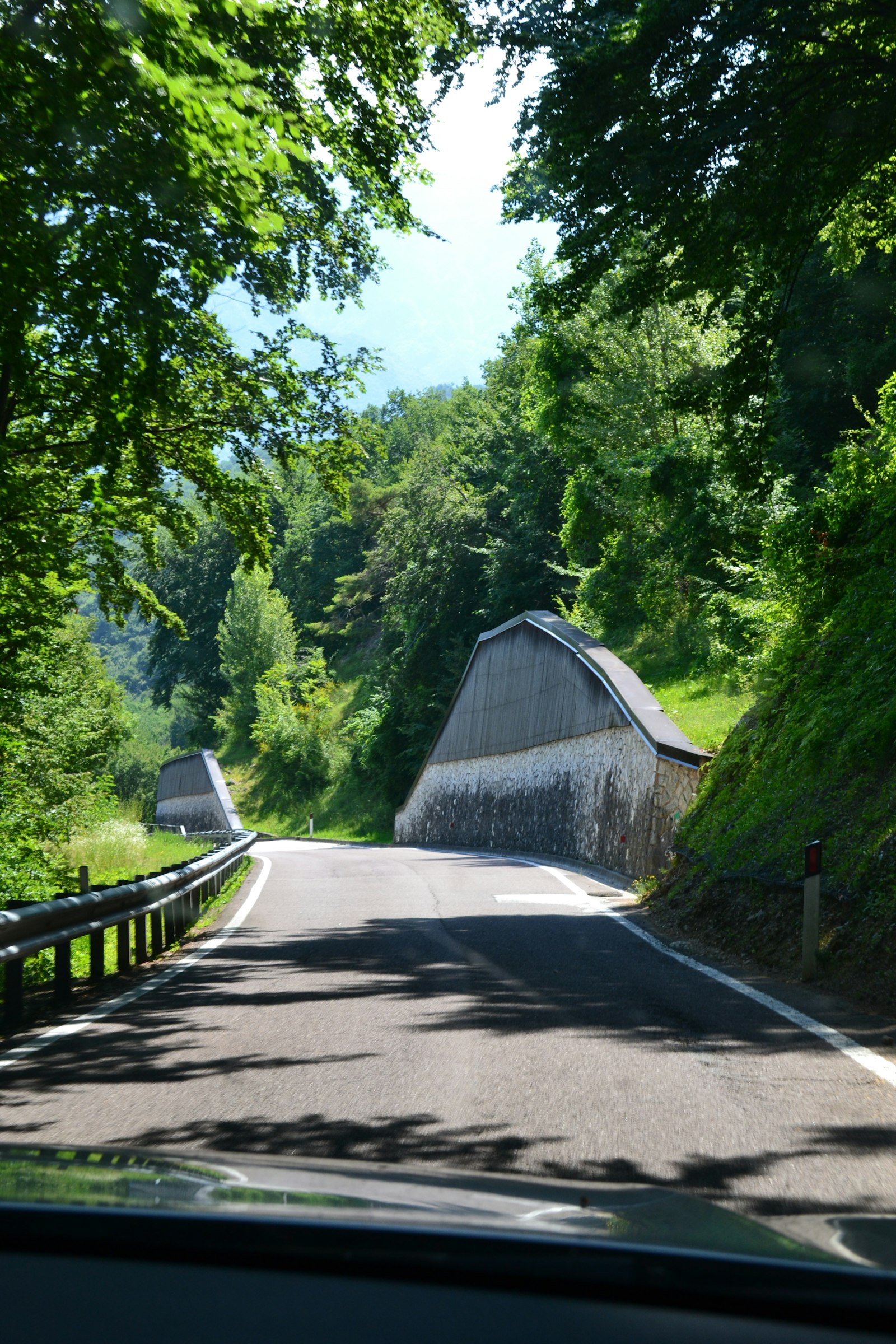 Narrow winding road through wooded hills where two vehicles cannot easily pass