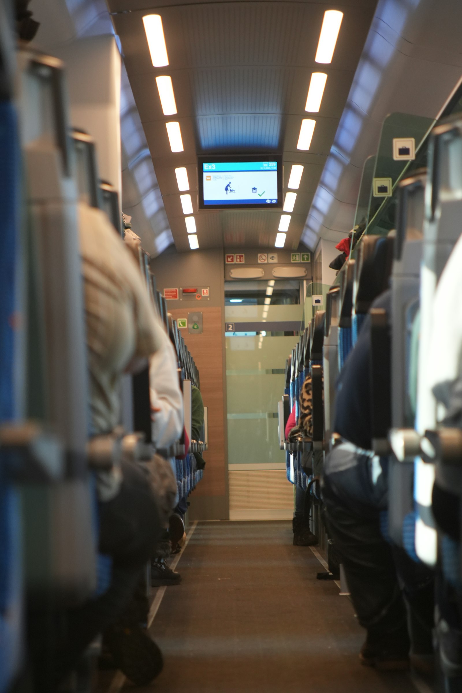 Passengers seated quietly inside a modern train carriage