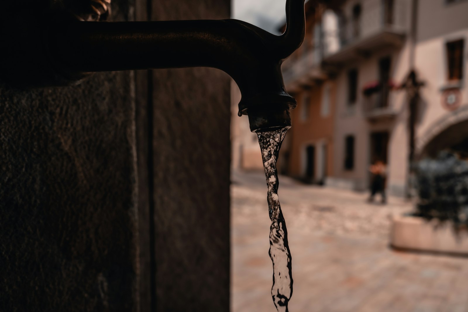Public street drinking water tap with water running from the spout