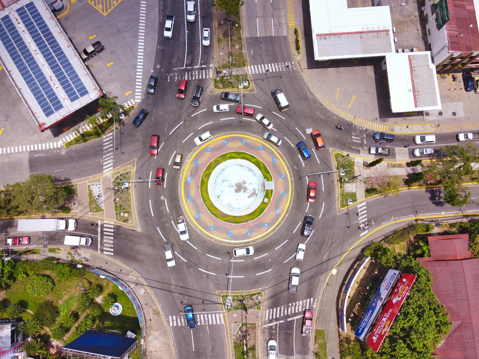 Roundabout seen from above with cars circulating in marked lanes