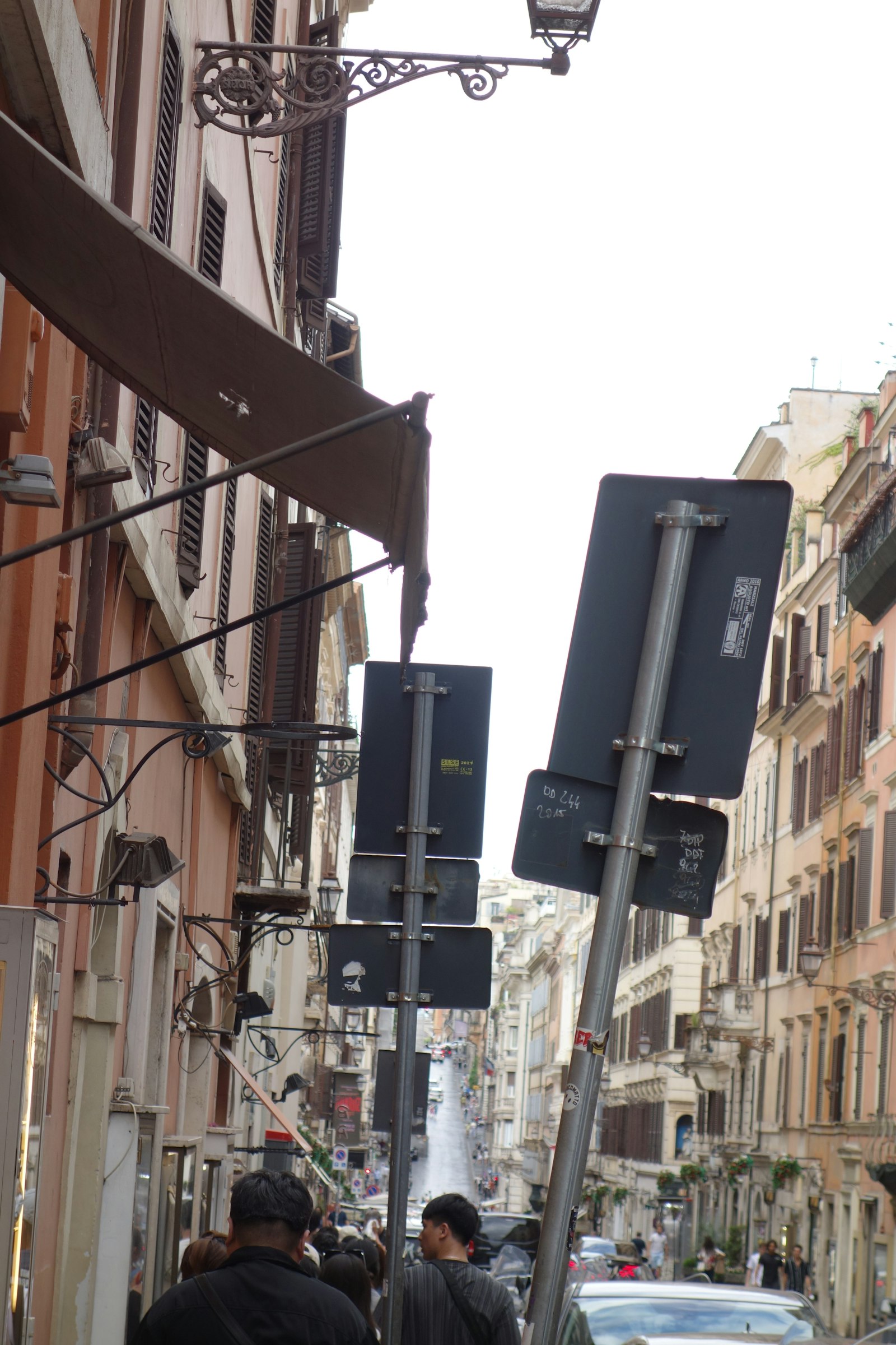 Street signs on a narrow Italian street marking access rules