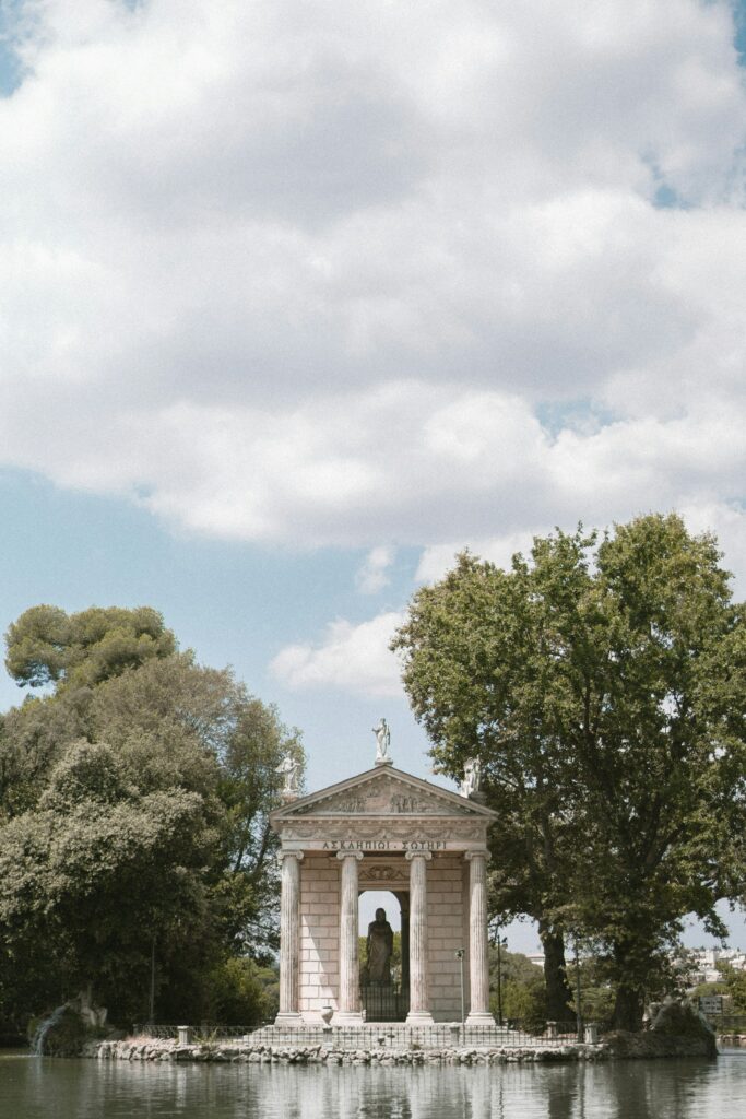 Trees and a historic building in the Villa Borghese gardens in Rome