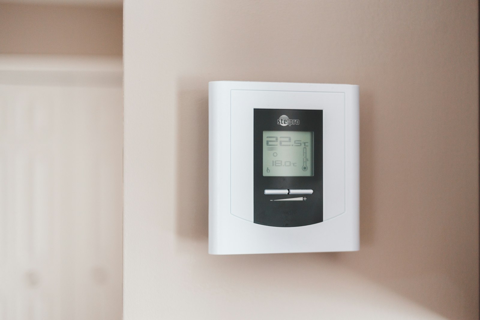 Wall thermostat display showing a room temperature of 19.5 degrees Celsius