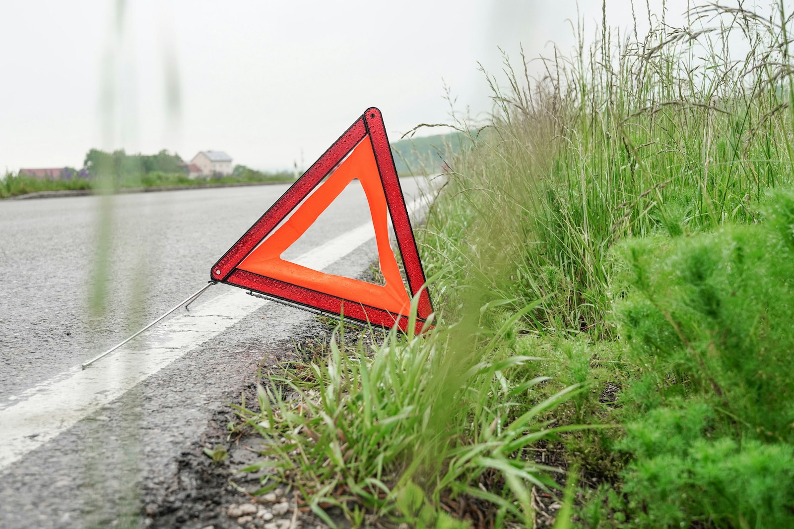 Red warning triangle placed on the road behind a stopped vehicle