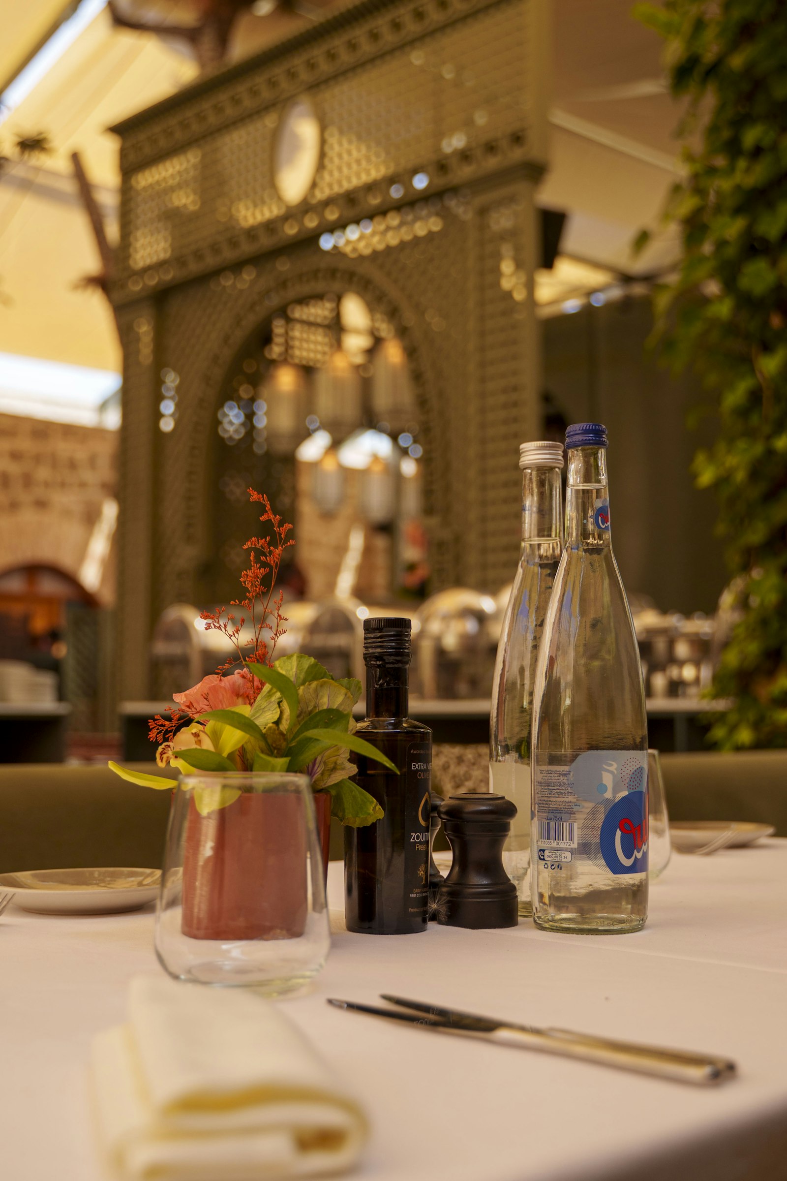 Water bottle and glasses set out on an outdoor restaurant table