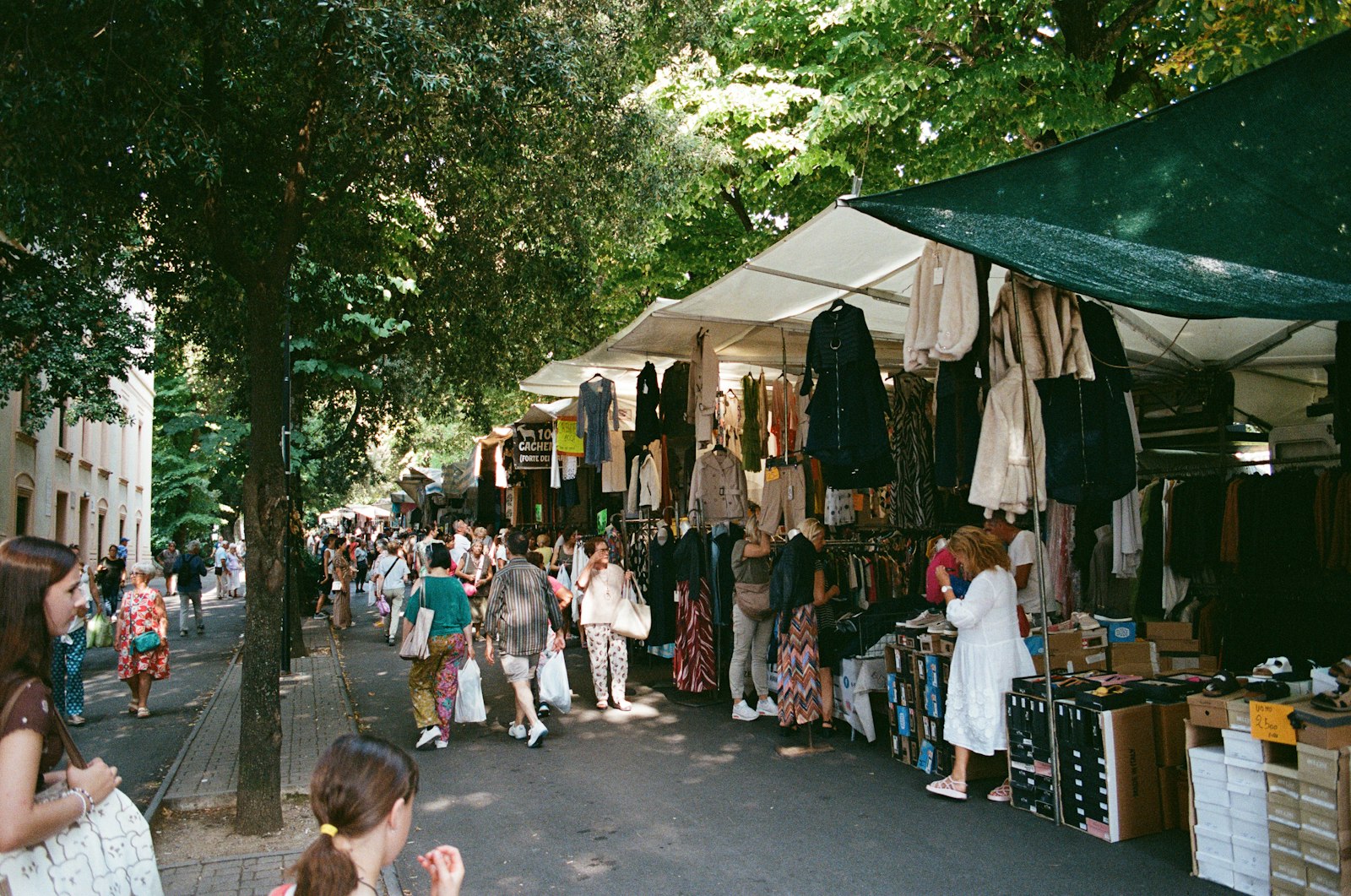 Stalls of a weekly street market filling a road in an Italian town