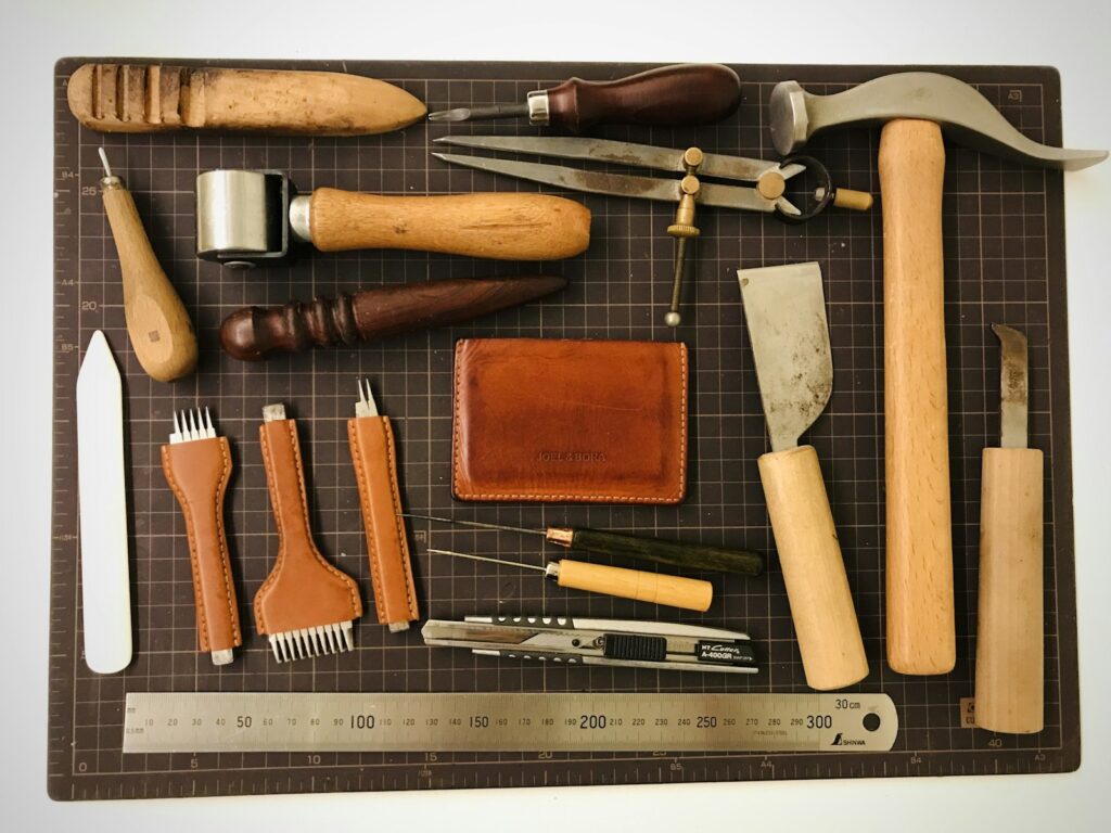 Leatherworking tools and leather pieces on a workbench