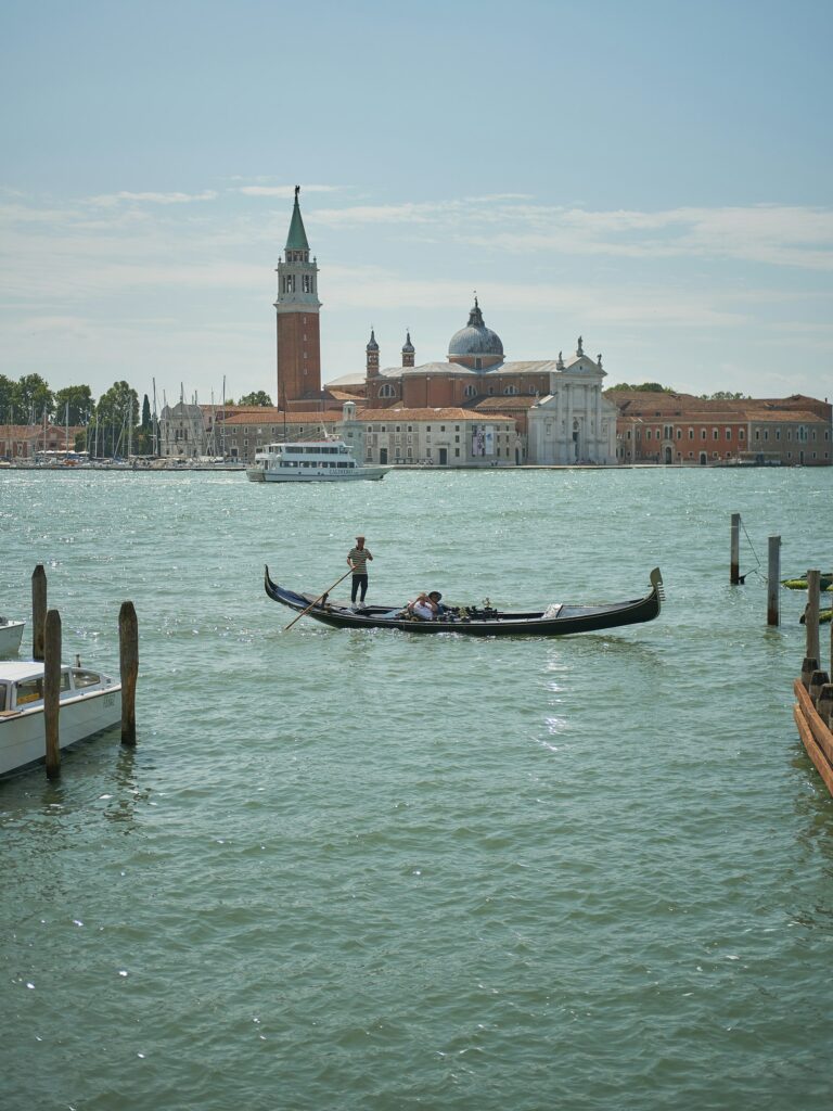 Traditional Venetian boat being rowed standing up on the lagoon